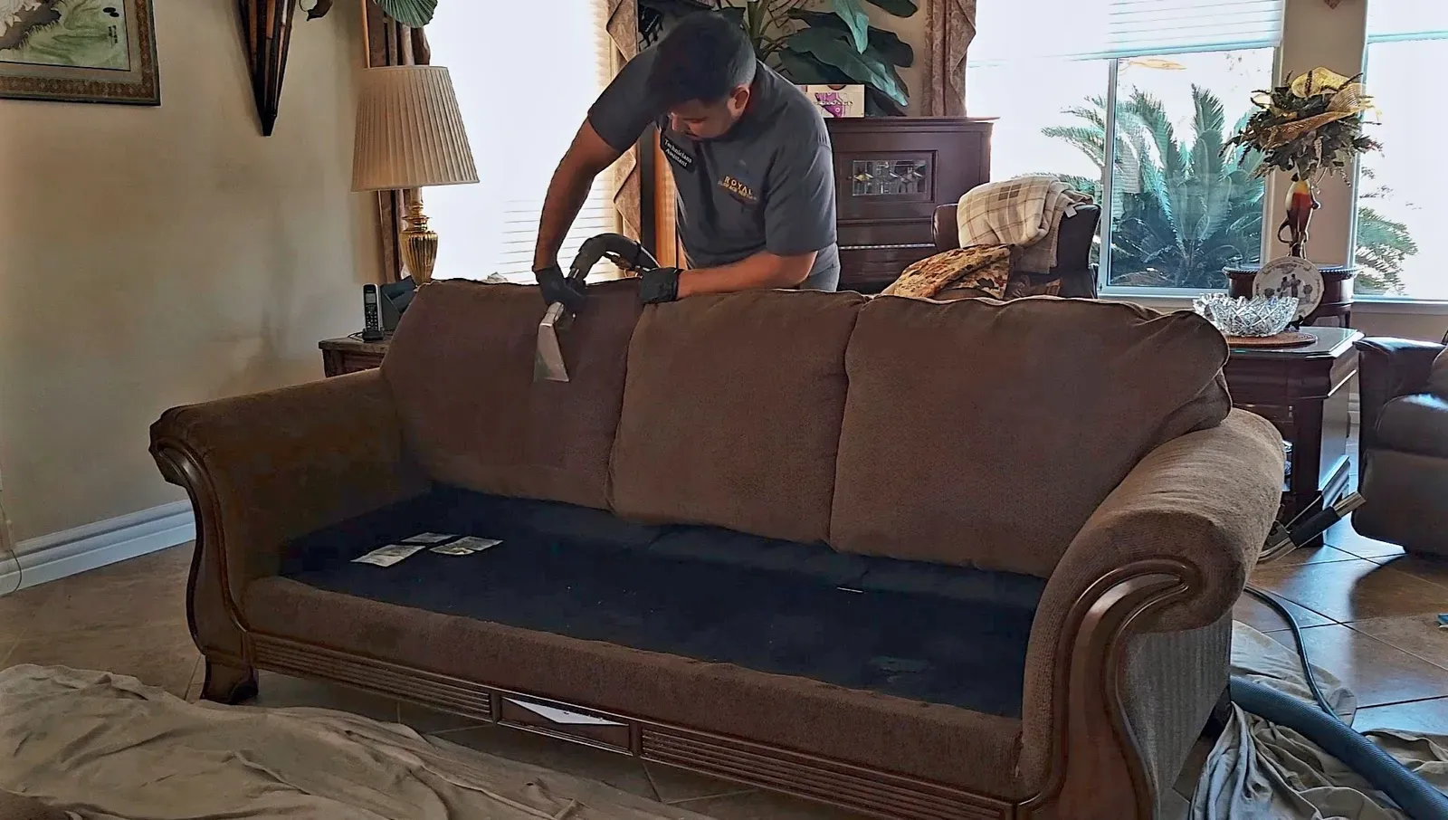 Royal Surface Restore technician cleaning a brown microfiber sofa with the cushions removed in a Las Vegas living room