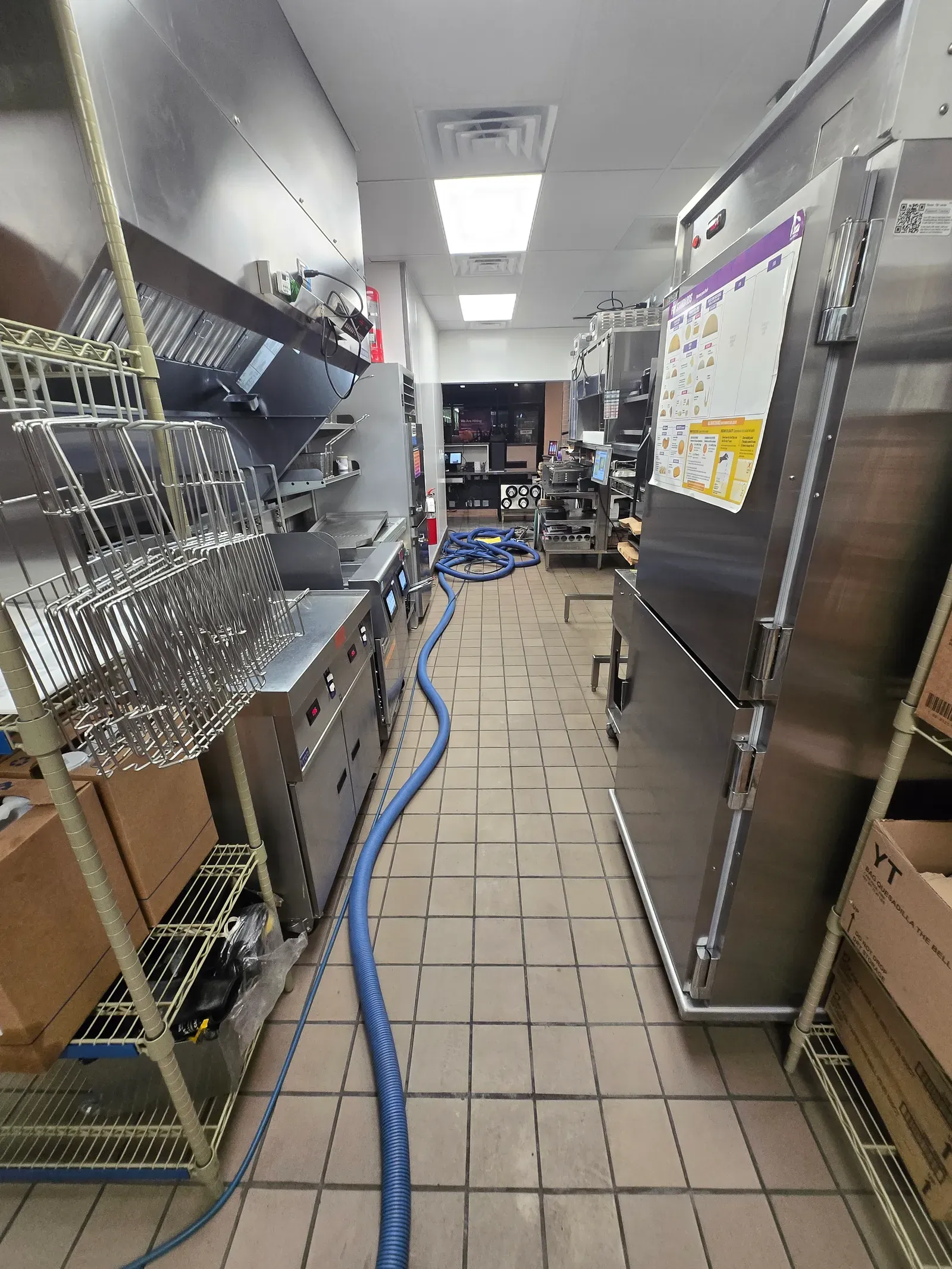 Vacuum hose run across the tile floor of a Las Vegas restaurant kitchen during commercial tile and grout cleaning