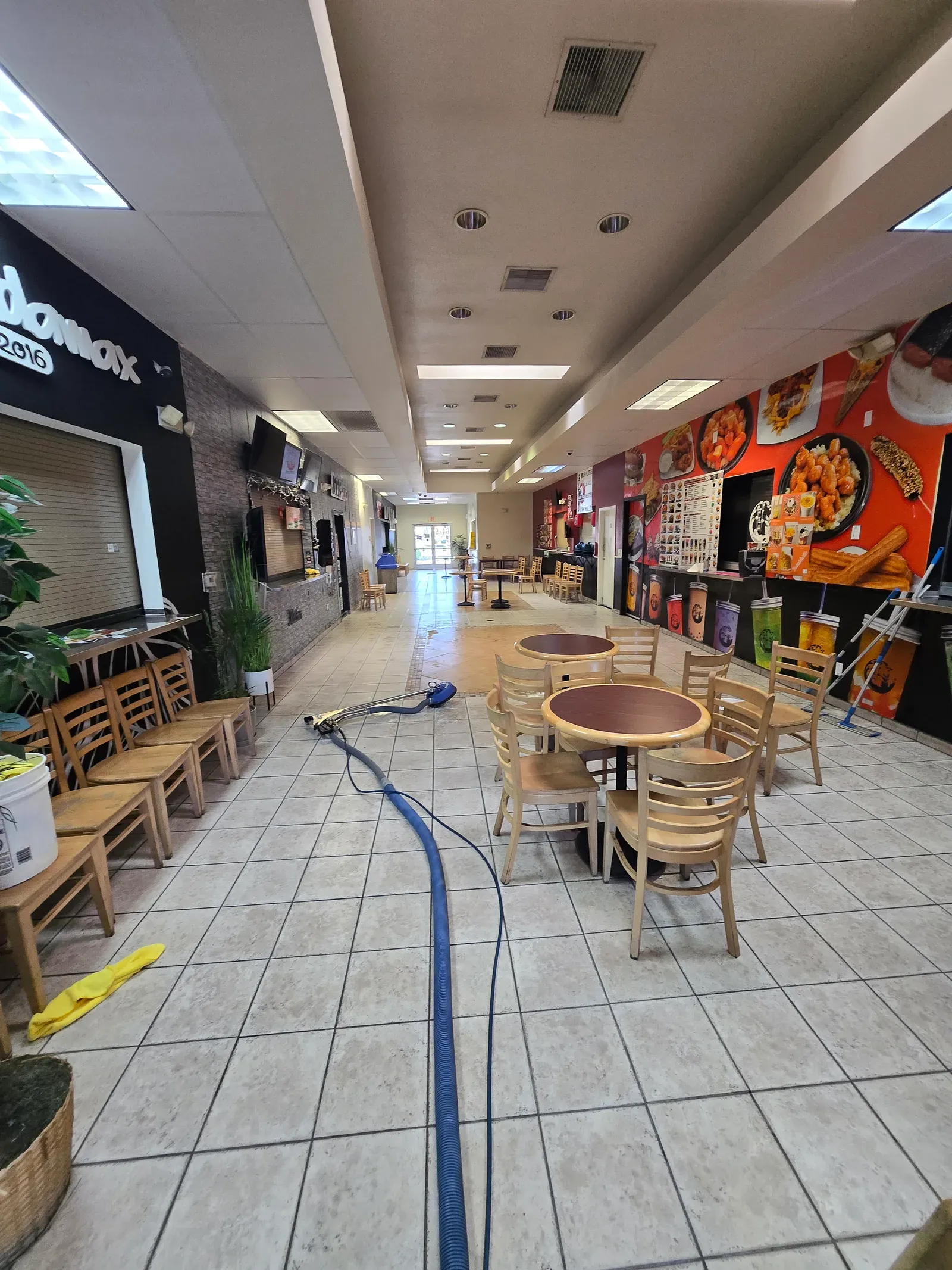 Tile and grout cleaning in progress across the seating area of a Las Vegas shopping center food court