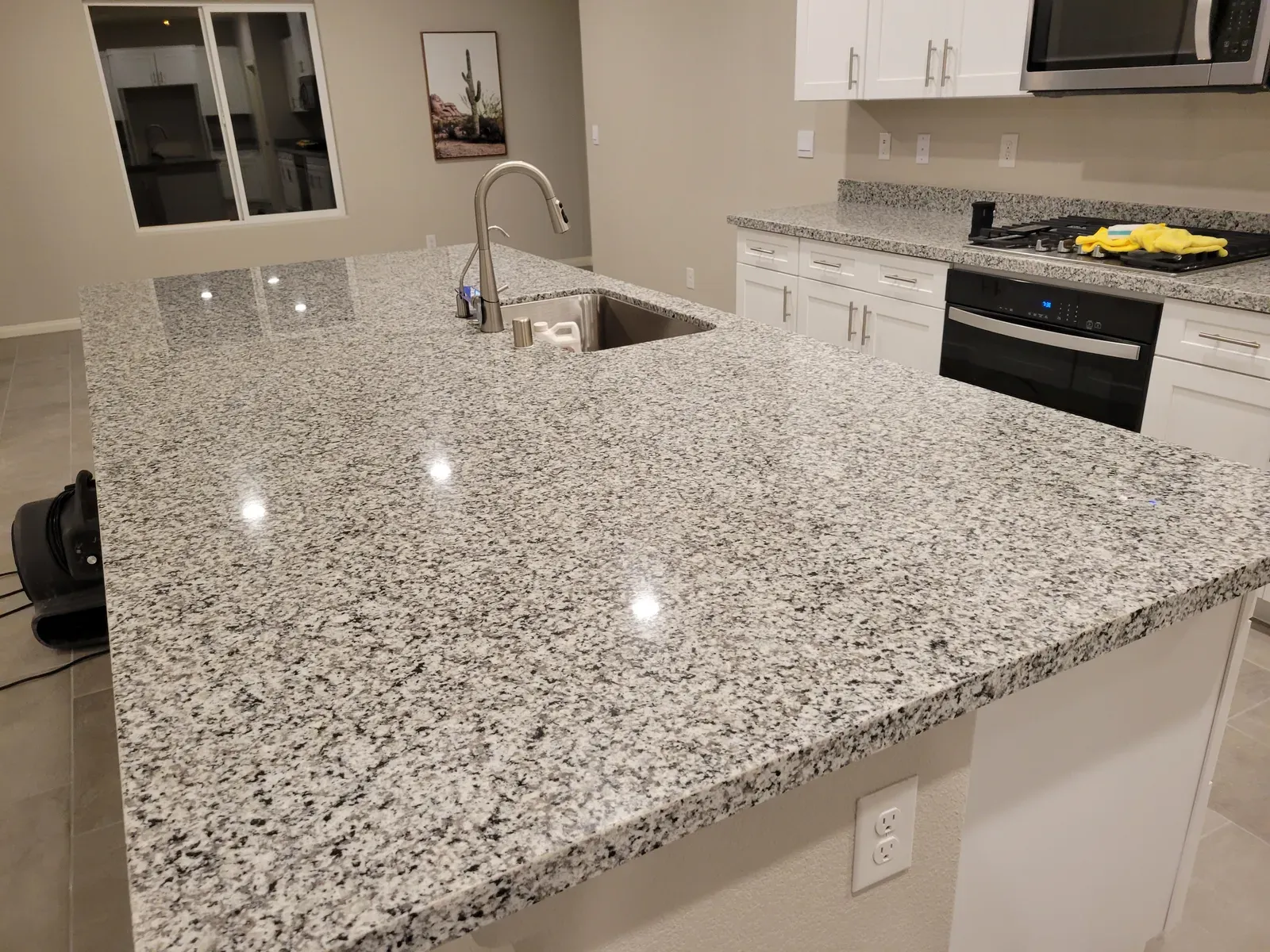 Sealed speckled granite kitchen island and peninsula with a glossy finish in a Las Vegas home