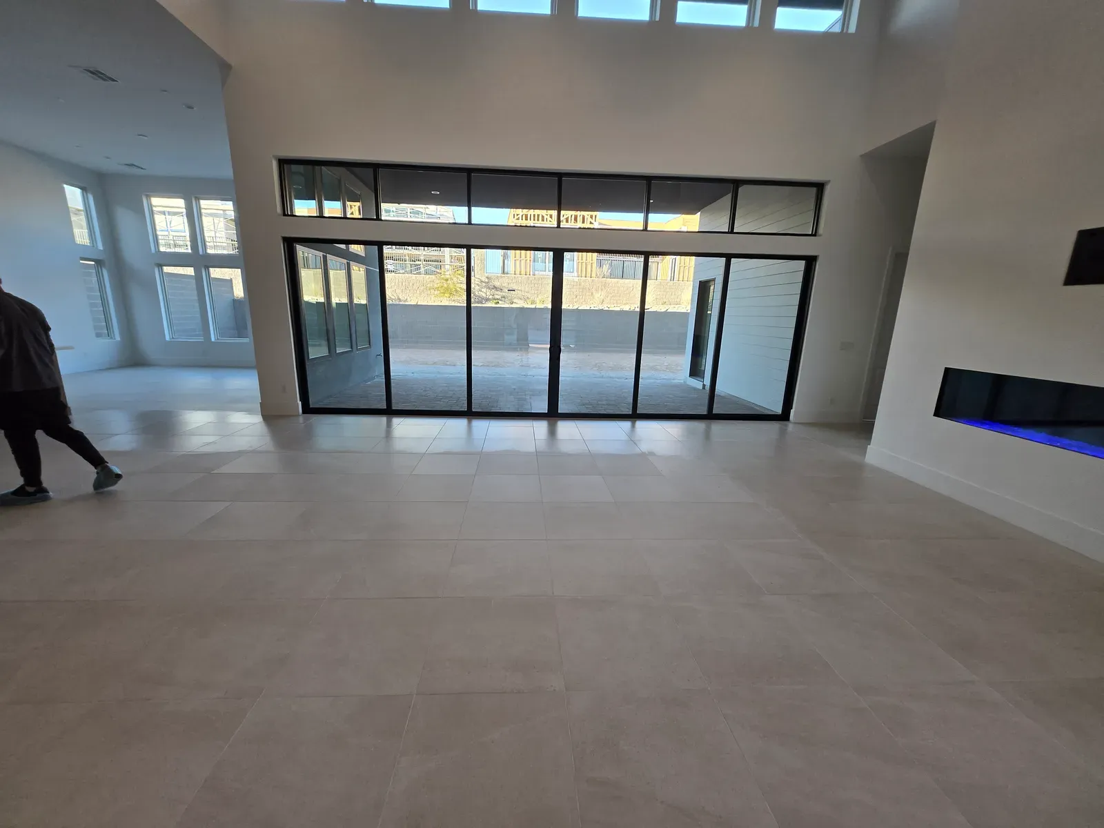 Large-format tile floor with sealed grout in a bright Las Vegas great room with floor-to-ceiling glass doors