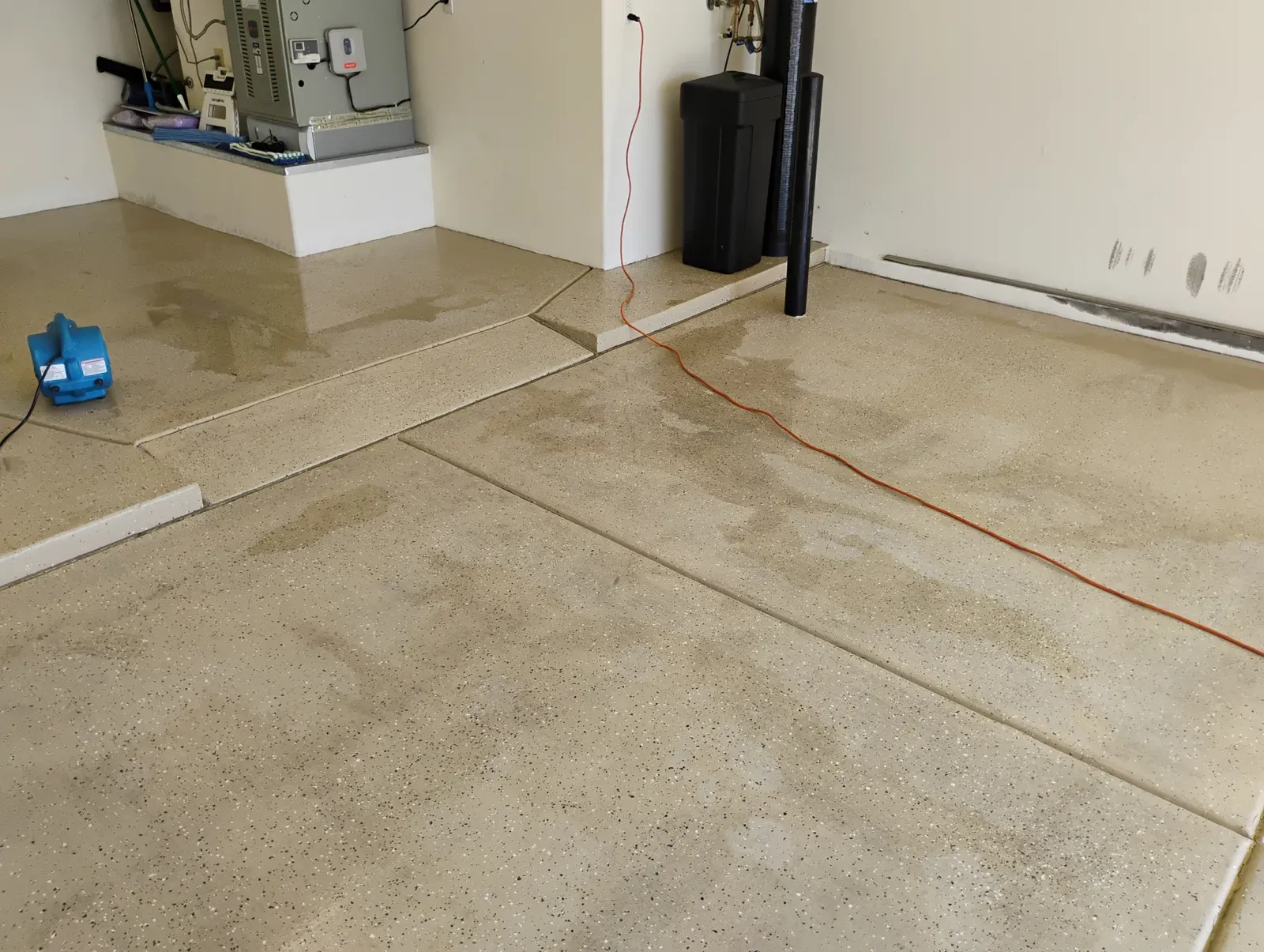 Freshly power washed garage concrete floor drying with an air mover in a Las Vegas home