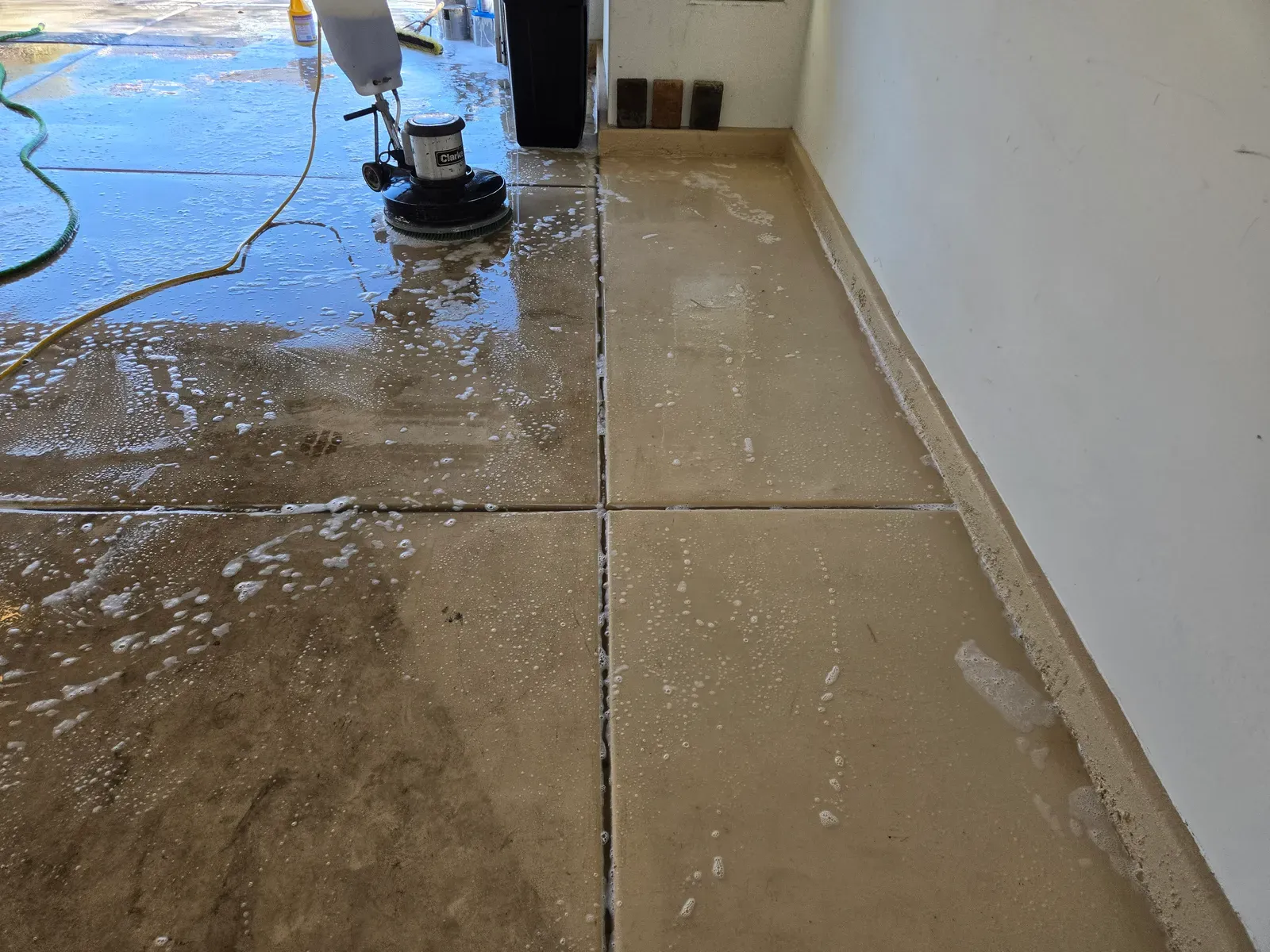 Floor machine scrubbing soapy water across a large tile patio during power washing in Las Vegas