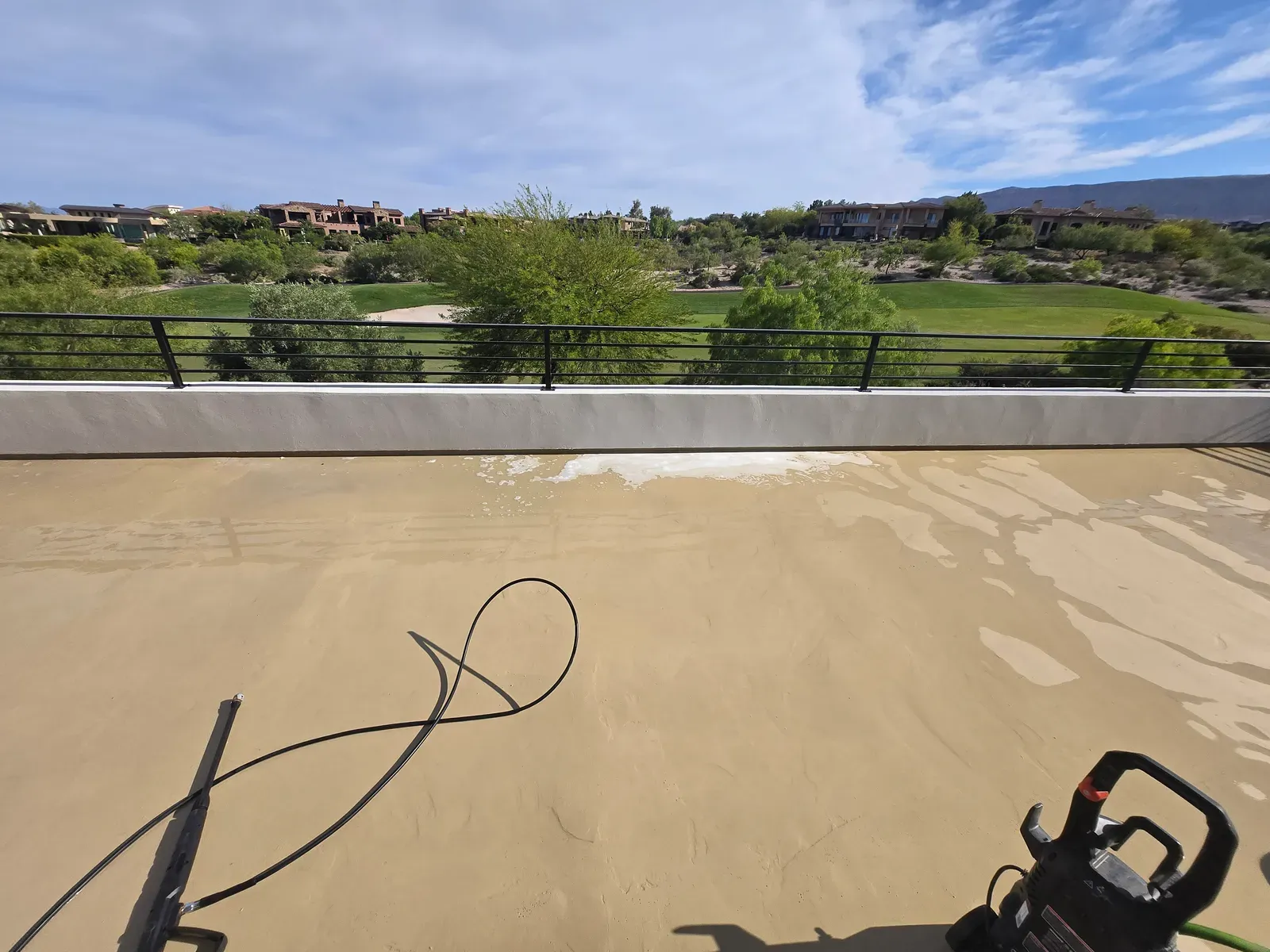 Pressure washing a rooftop deck overlooking a Las Vegas golf course and desert homes