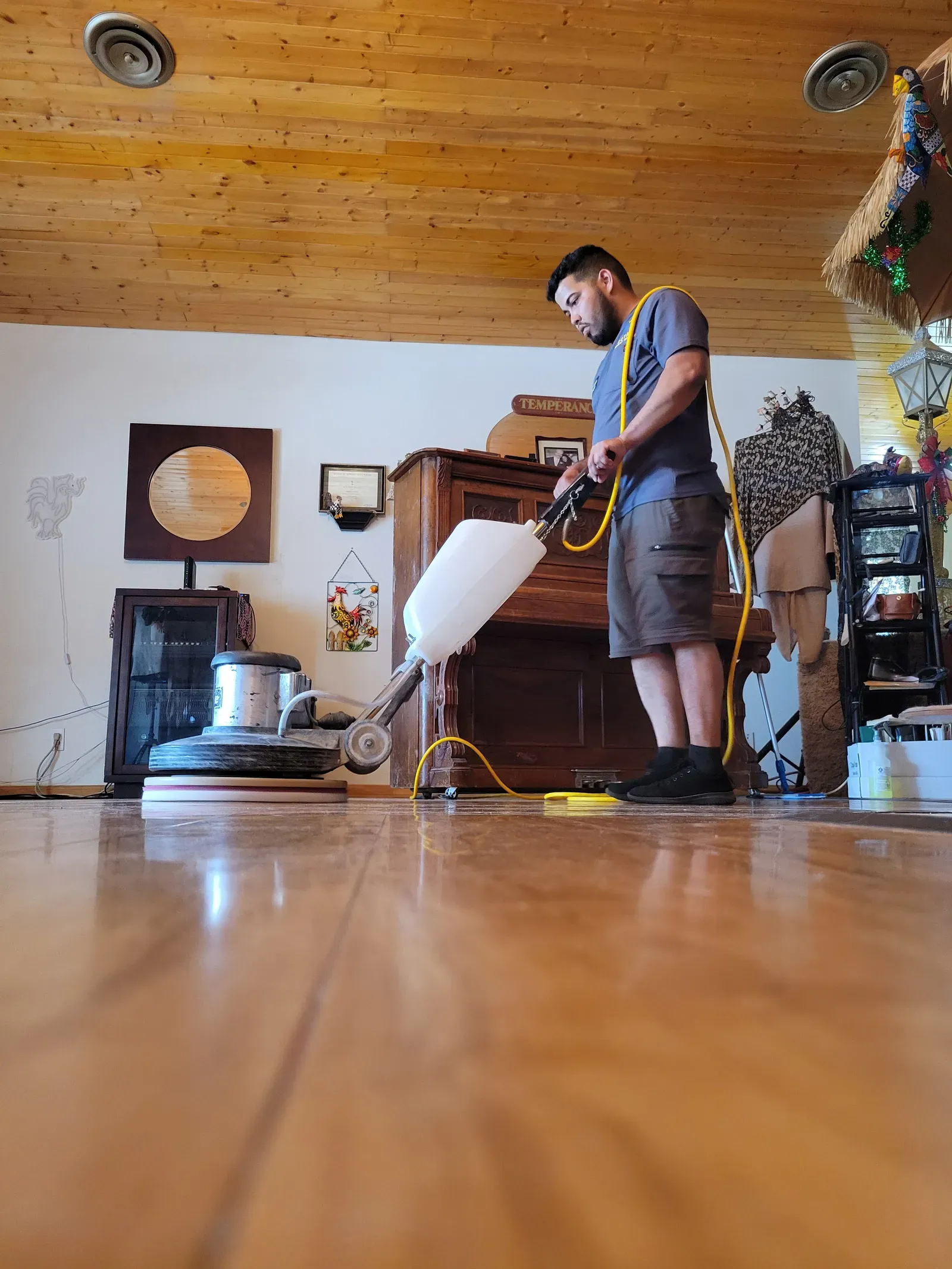 Technician polishing a glossy stone floor with a rotary machine in a Las Vegas home