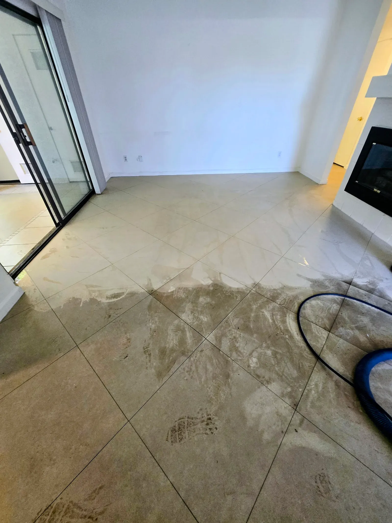 Diagonal cream tile living room floor mid-cleaning with an extraction tool in a Las Vegas home