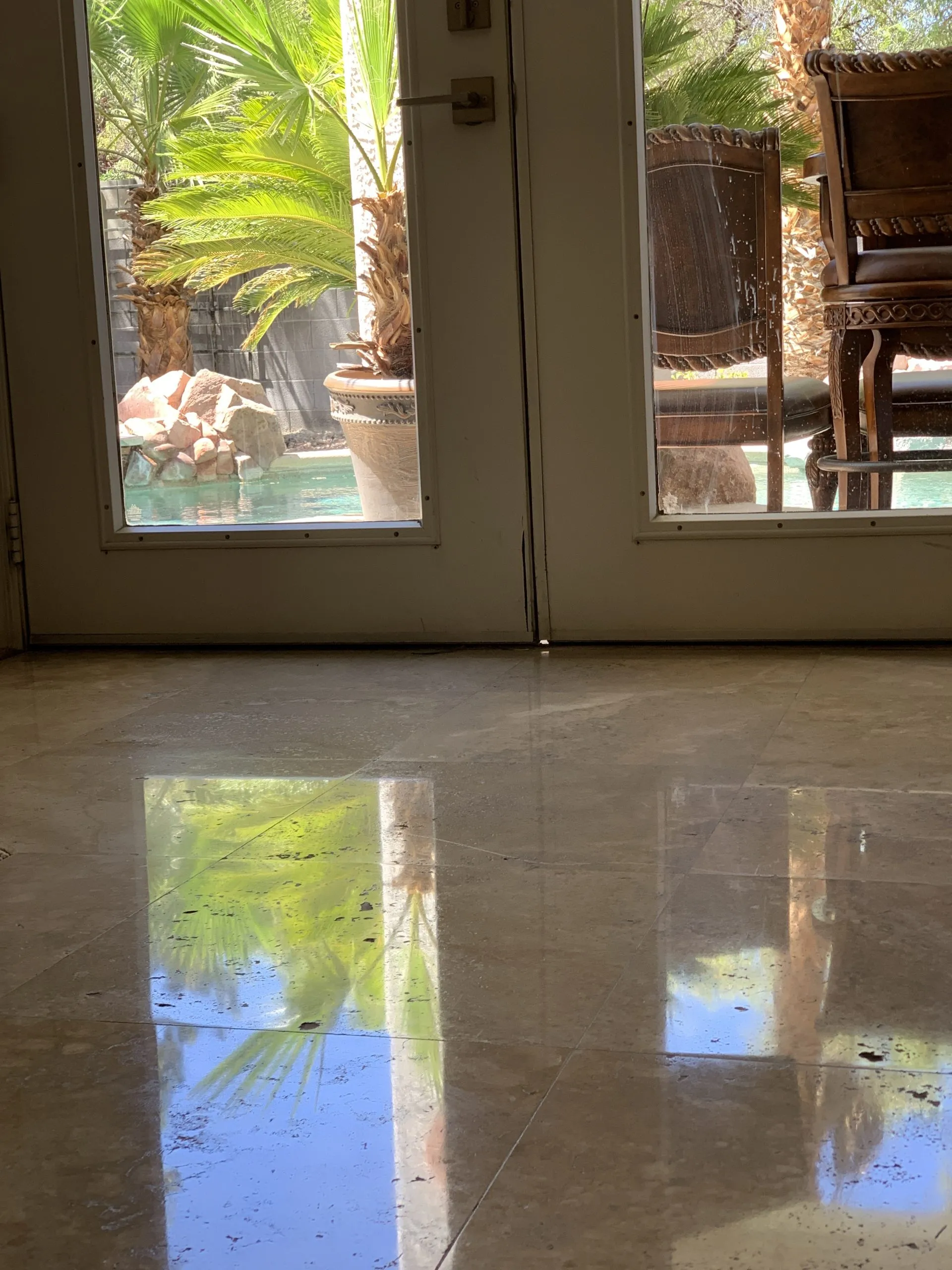 Polished travertine flooring at a back door with pool view in a Las Vegas home